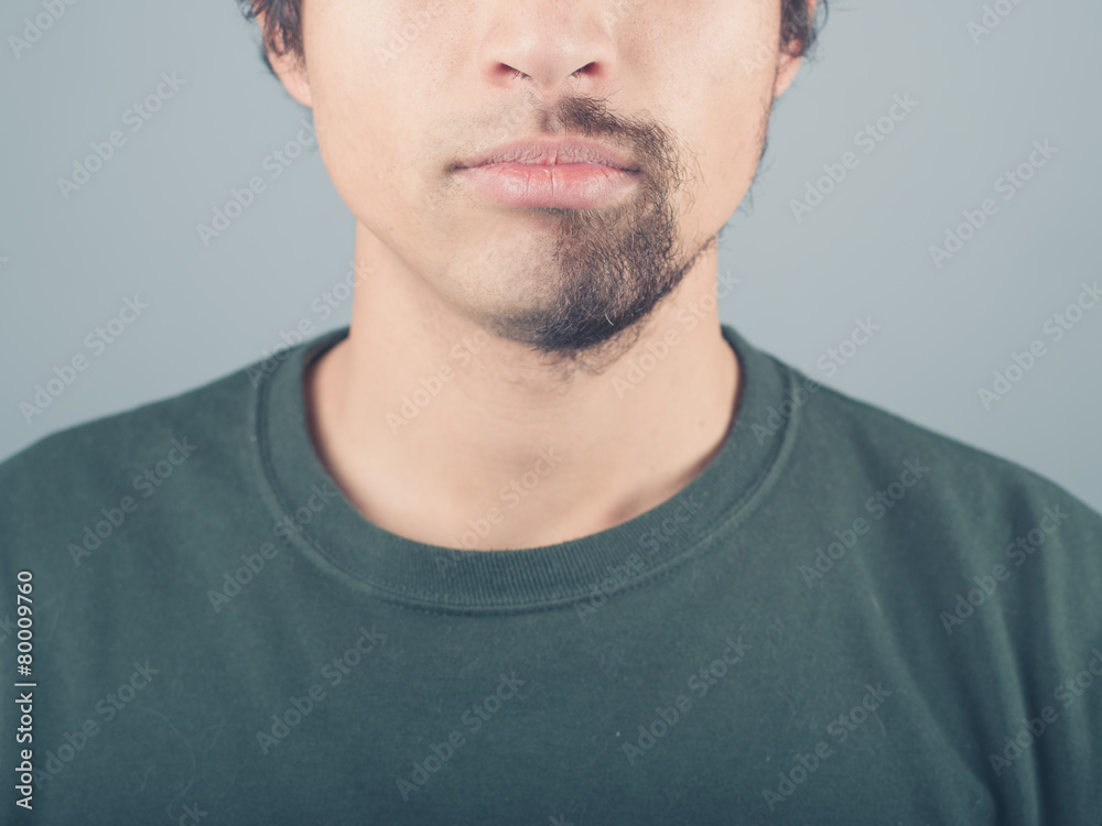 Obraz premium Young man with half shaved beard