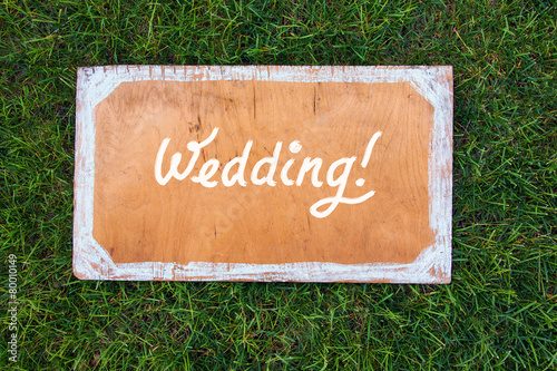 wedding wooden sign on the grass. Spring or summer theme for ads © Magryt