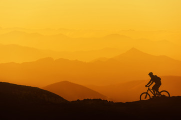 biker riding on mountain silhouettes background