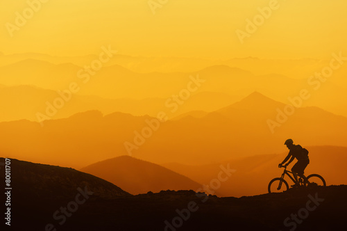 biker riding on mountain silhouettes background © mimadeo