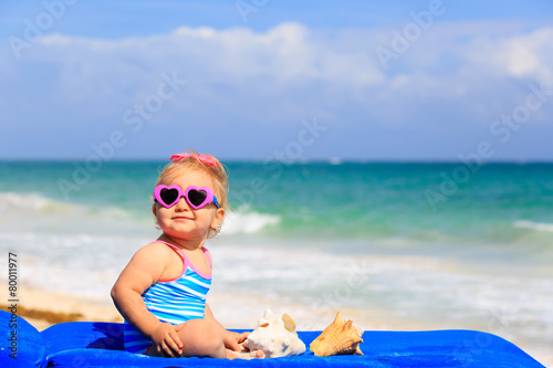 cute little girl  with seashells on the beach
