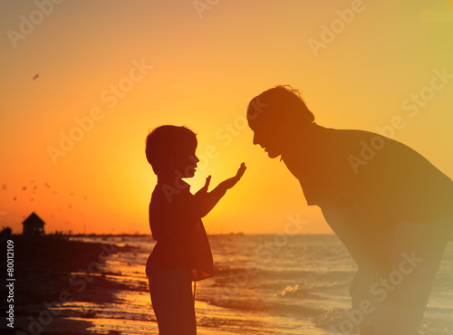 father and little son talking at sunset