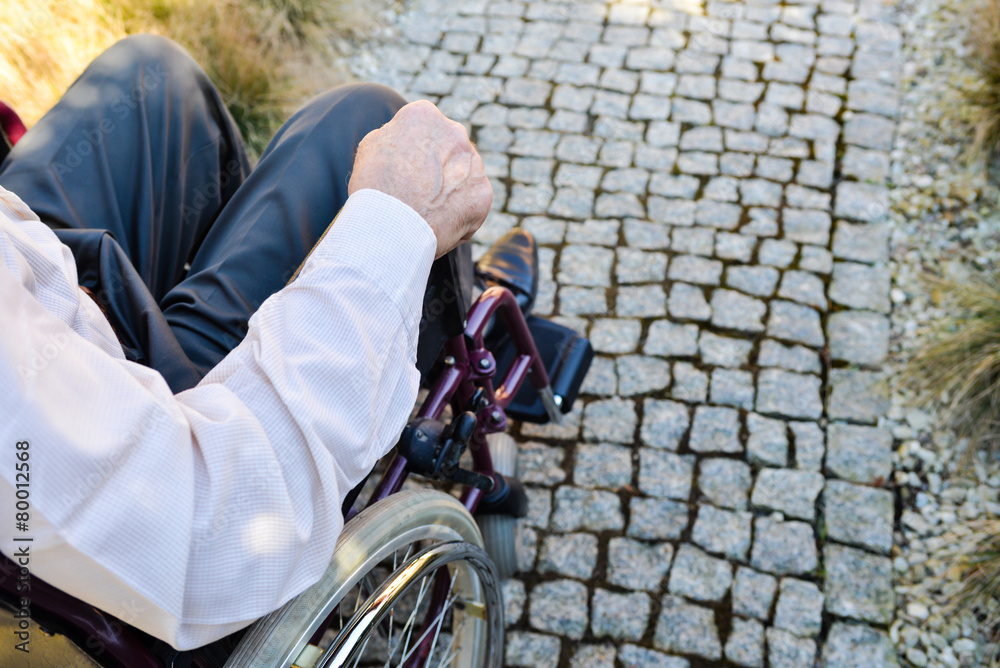 Obraz premium Close-up of male hand on wheel of wheelchair