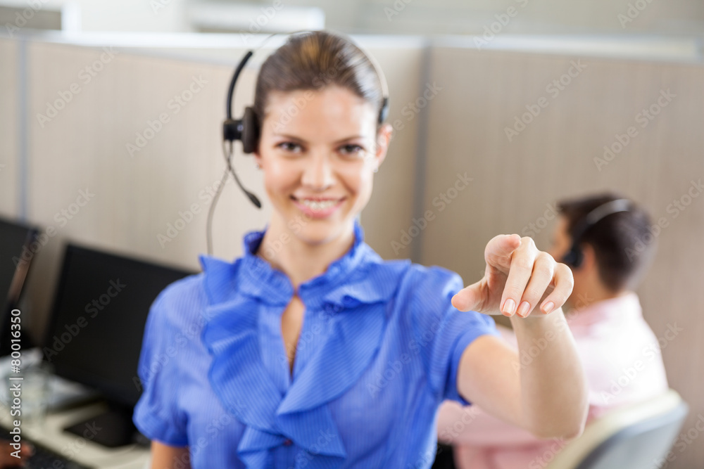 Smiling Call Center Employee Pointing In Office Smiling Call Center Employee Pointing In Office