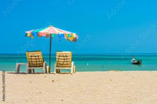 Beach umbrellas and sunbathe seats on Phuket sand beach in South