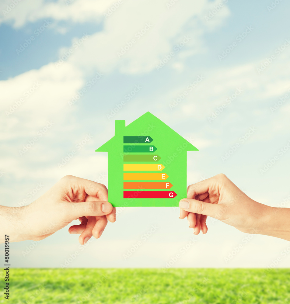 Naklejka premium hands holding green paper house