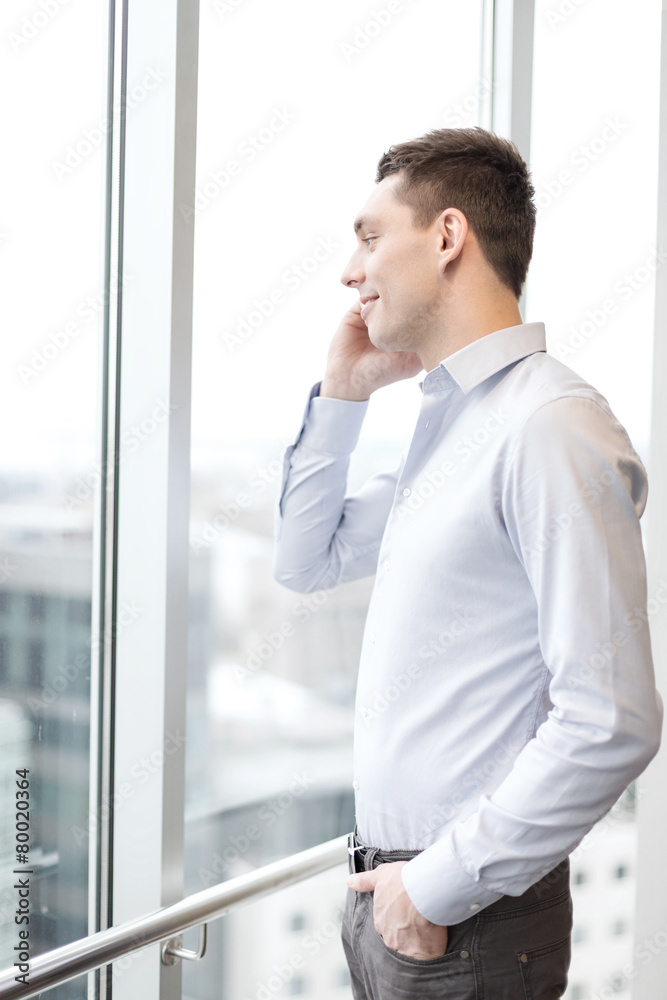 smiling businessman with smartphone in office smiling businessman with smartphone in office