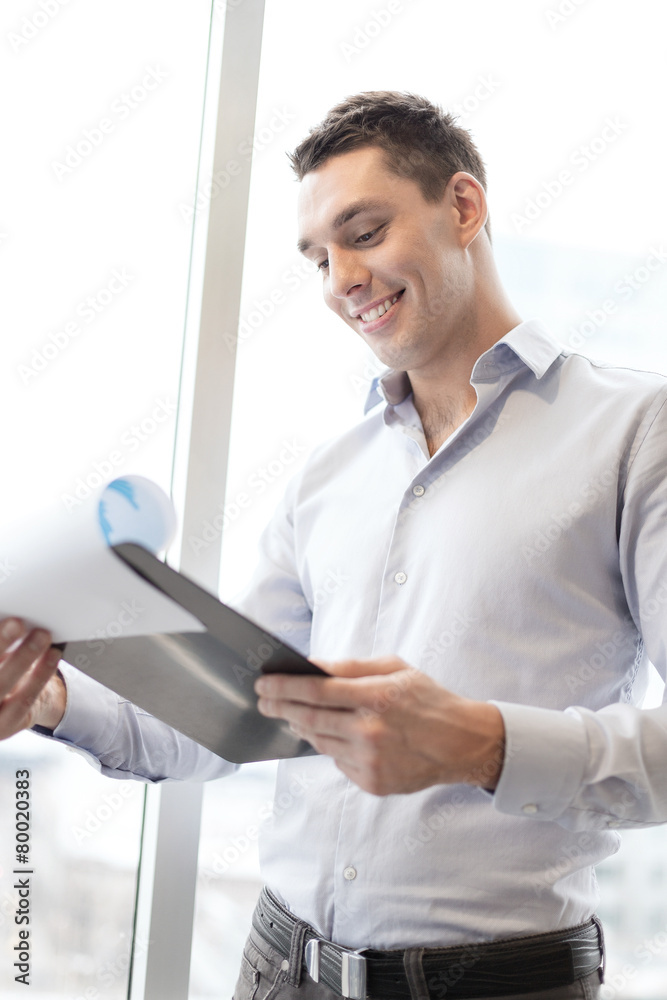 smiling businessman with clipboard in office smiling businessman with clipboard in office