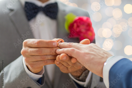 close up of male gay couple hands and wedding ring photo