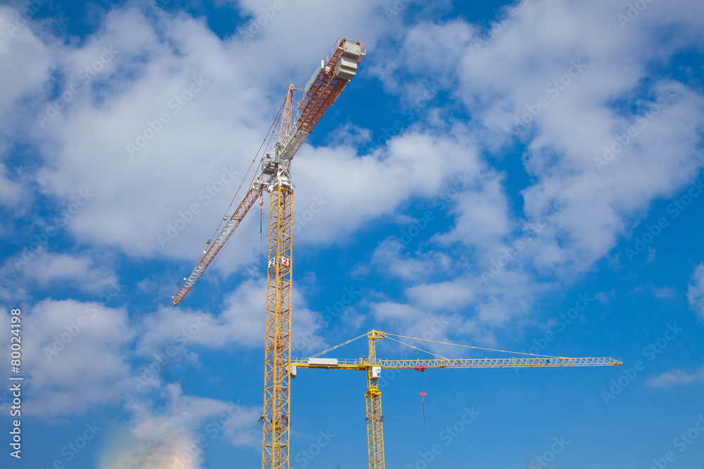 Construction cranes against beautiful cloudscape