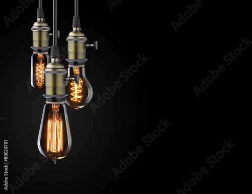 Old glowing light bulbs on black background