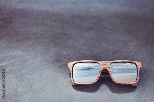 double exposure of wooden sunglasses and beach