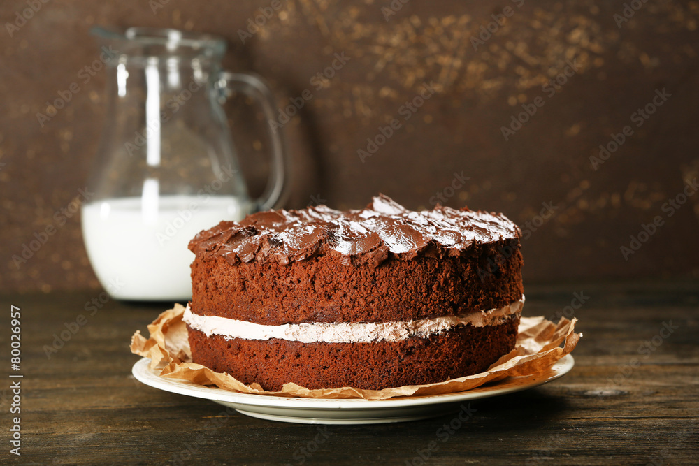 Delicious chocolate cake on table on brown background Delicious chocolate cake on table on brown background
