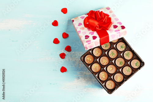 Gift box with tasty chocolate candies on wooden table © Africa Studio