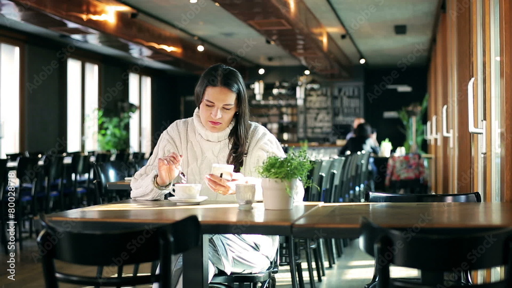 Woman sitting in the restaurant and using smartphone Woman sitting in the restaurant and using smartphone