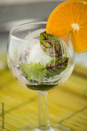 A glass with frosted leaves and orange