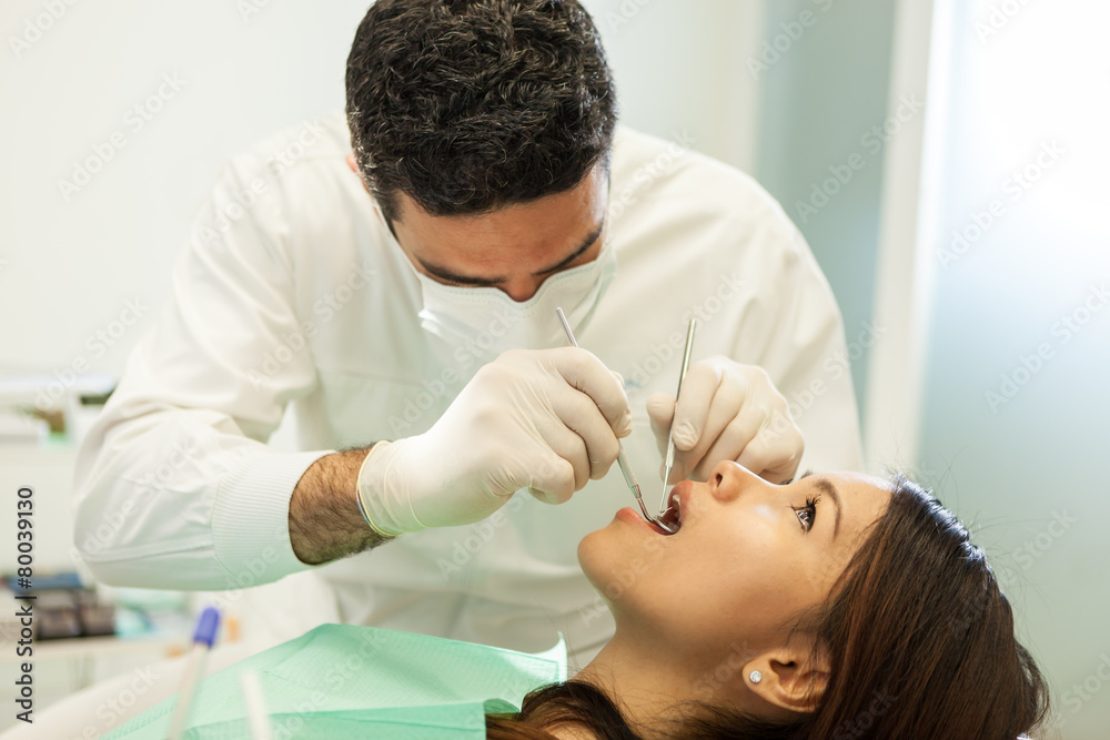 Fototapeta premium caucasian dentist is visiting an asian woman