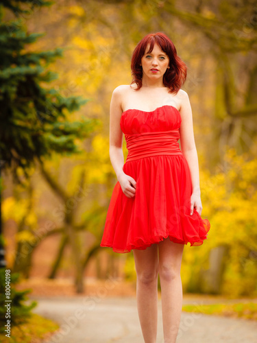 Fashion woman red dress relaxing walking in park