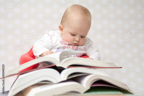 Baby with pile of books