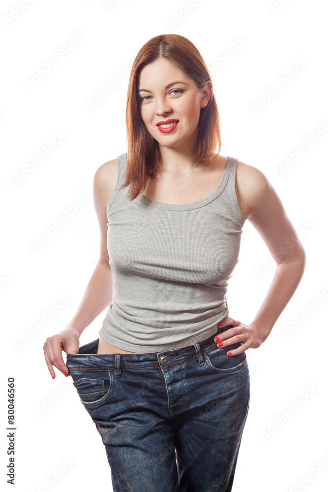 Obraz premium young smiling woman in big jeans showing successful weight loss