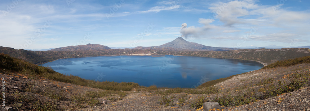 Volcanic eruption. Smoke over mountain lake.