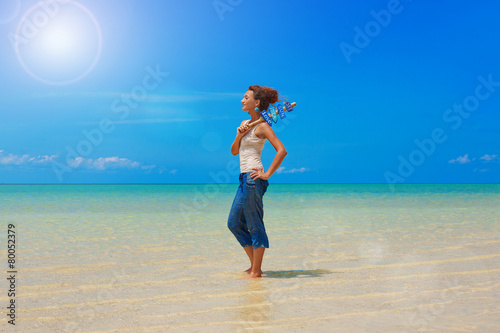 Beautiful girl with signpost in her hands on the beach