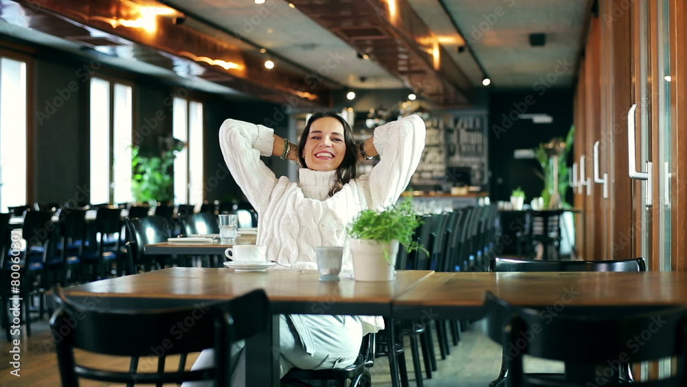 Happy woman relaxing in the restaurant and smiling to the camera