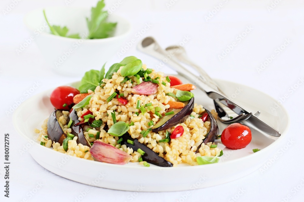 Bulgur salad with vegetables and herbs on a white background.
