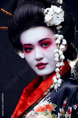 young pretty geisha in kimono with sakura and decoration photo