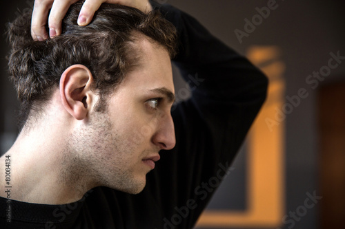 Side view portrait of a young man with curly hair