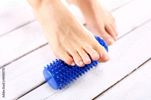Kobieta masuje stopę masażerem