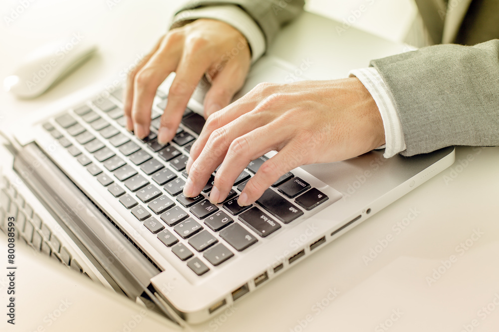 Closeup of businessman hands typing on laptop computer
