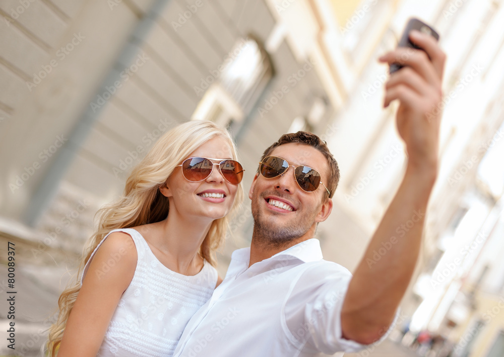 smiling couple with smartphone in the city smiling couple with smartphone in the city