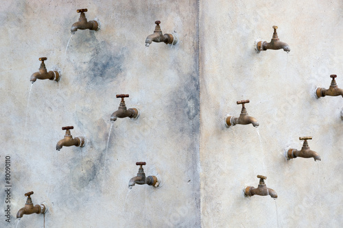 Billede på lærred Many water taps mounted on the wall