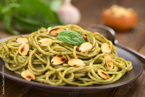 Pasta with pesto made of basil and spinach garnished with almond