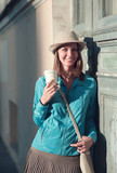 Beautiful hipster woman in hat and blue jacket with cup of coffe
