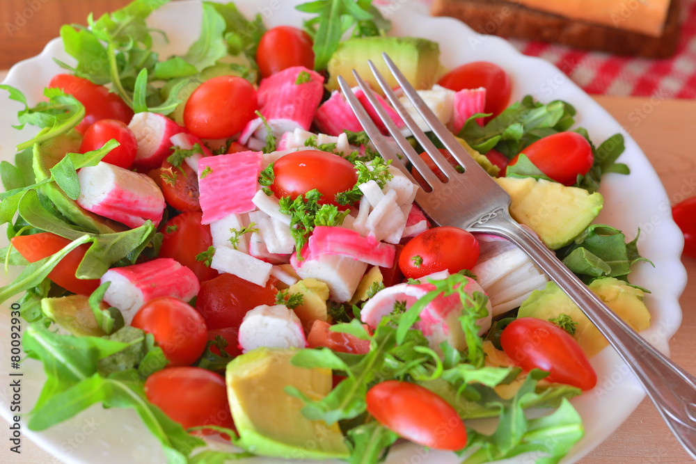 Mixed vegetable salad with crab sticks and avocado