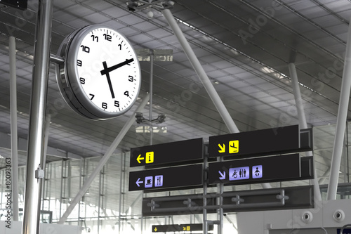 Clock and signs at an airport