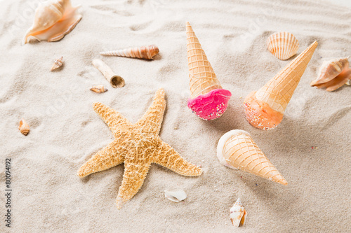 Ice cream scoops on sandy beach.