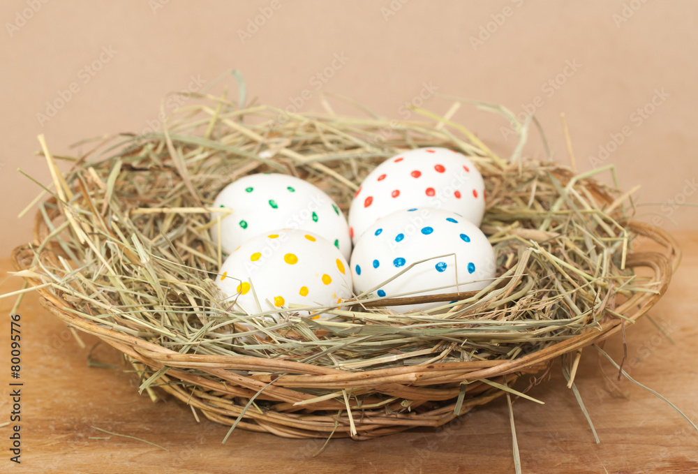 Obraz premium four spotted colored easter eggs in hay