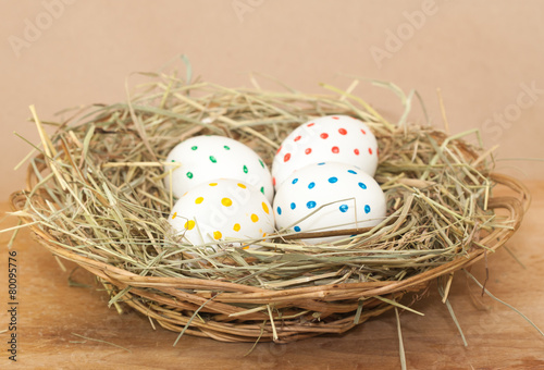 four spotted colored easter eggs in hay