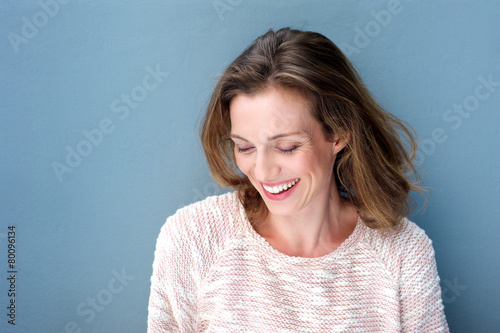 Beautiful mid adult woman laughing with sweater © mimagephotos