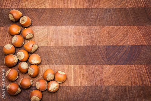 Wooden background with hazelnuts and copy space