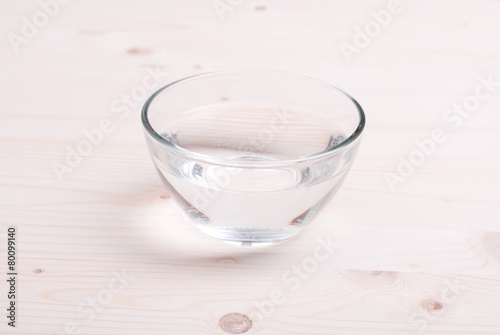 water in a glass and a napkin on the board