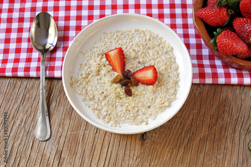 bowl with porridge on a set table for breakfast