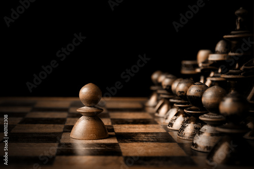 Obraz na plátně Šachy. Bílý pěšec proti celé černé.