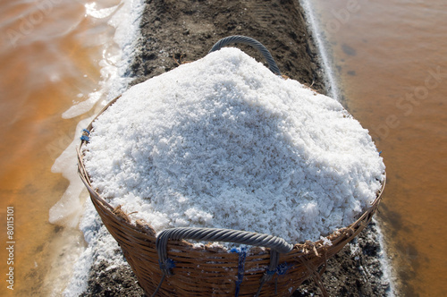 salt in the bamboo basket on the ground near salt pan, Thailand photo