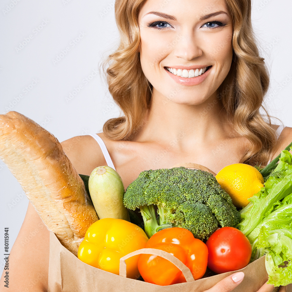 Portrait of woman with vegetarian food, on grey