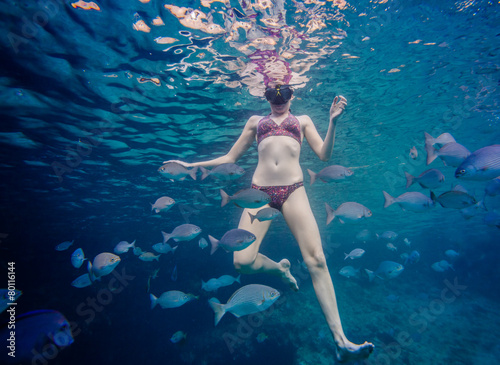 Girl Snorkeling and Surrounded with Chopa Fish