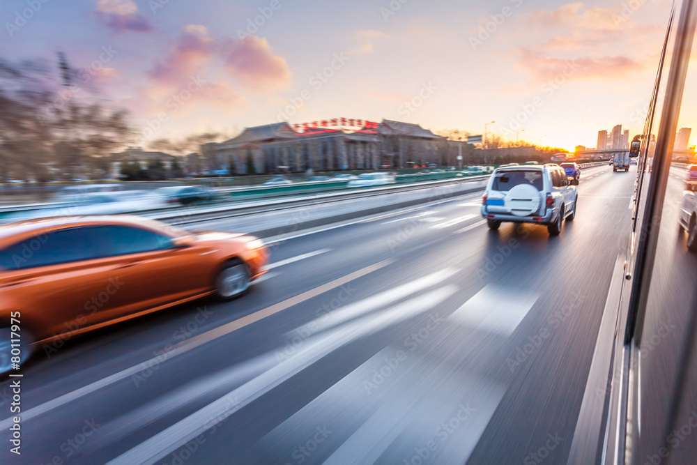 Fototapeta premium Car driving on freeway at sunset, motion blur